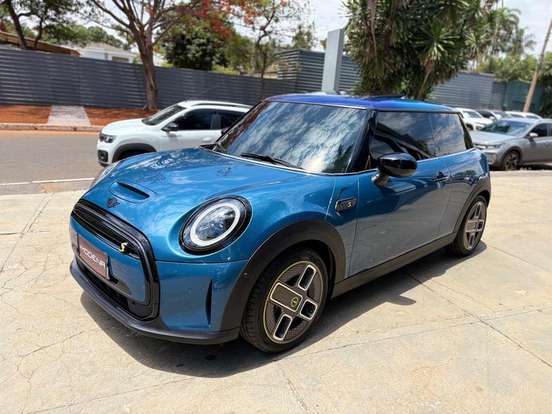 MINI Cooper SE Top 2P Elétrico em cor azul vibrante estacionado em área urbana, destacando seu design moderno e elétrico.