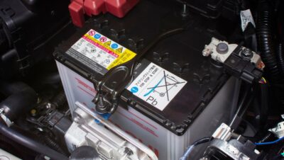 Bateria de carro instalada corretamente no compartimento com terminais visíveis